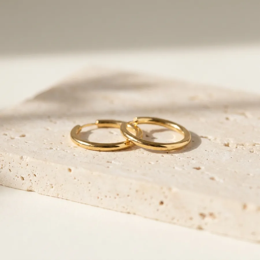 Gold hoop earrings in the same signature warm-daylight style